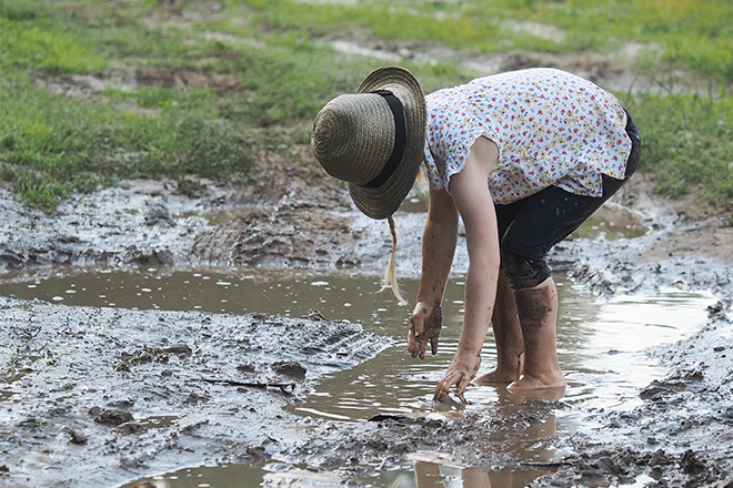Student playing in mud