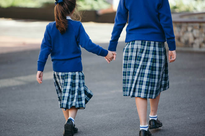 2 students walking and holding hands